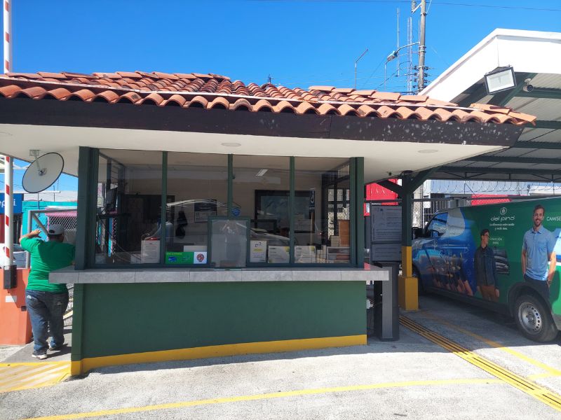 Caseta de cobro de un parqueo en Costa Rica, con ventanilla de atención y aguja de acceso